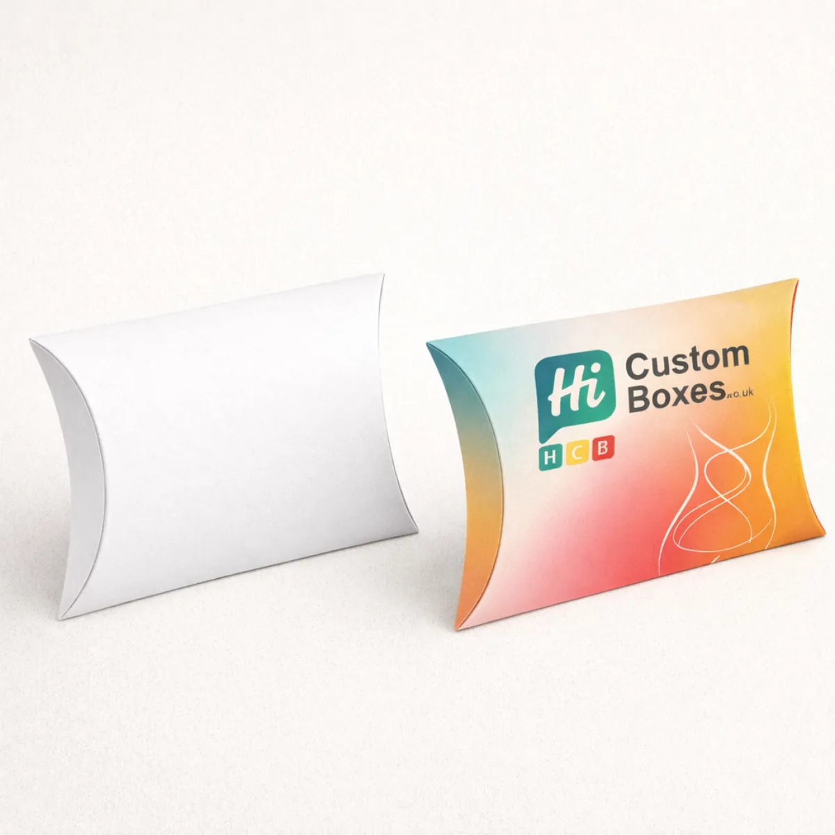 Two curved pillow-style boxes- one blank white and one printed with a logo and orange-to-teal gradient- class=
